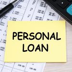 The inscription personal loan on a yellow sheet that lies on the financial document near the calculator.